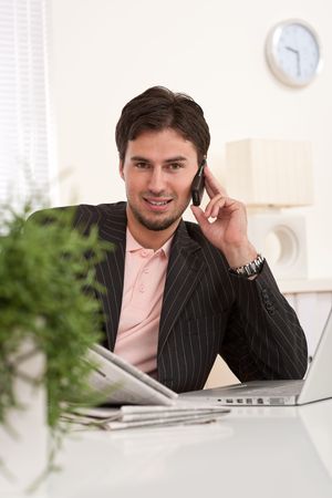 Young businessman on the phone working at officeの写真素材
