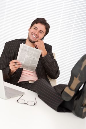 Young businessman on the phone with legs upの写真素材