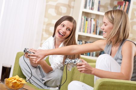 Students - Two happy female teenager playing TV game and having funの写真素材