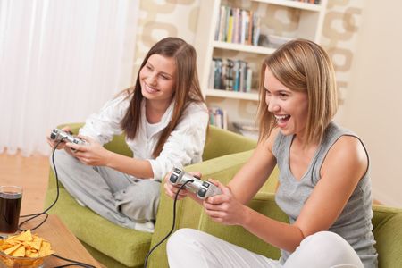 Students - Two happy female teenager playing TV game and having funの写真素材