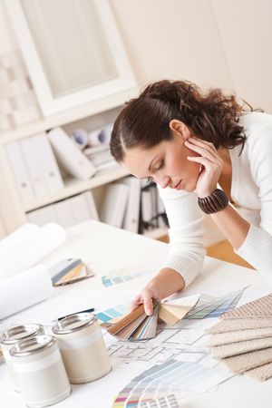 Young female interior designer at office with paint and color swatchの写真素材