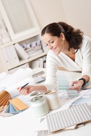 Female interior designer working at office with color swatch and paintの写真素材