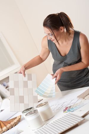 Female interior designer working at office with color swatch choosing color of tilesの写真素材