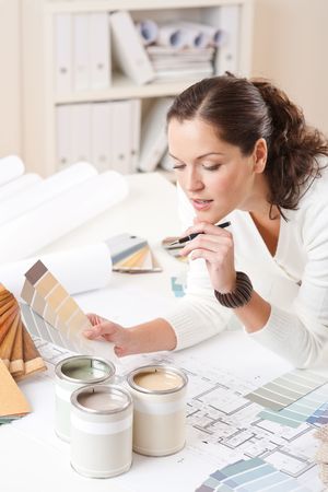 Young female interior designer at office with paint and color swatchの写真素材