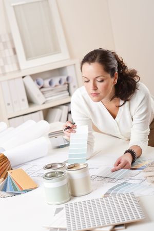 Female interior designer working at office with color swatch and paintの写真素材