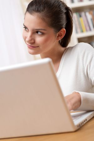 Students - Happy teenager with laptop in modern lounge sitting on armchairの写真素材