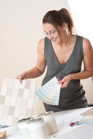 Female interior designer working at office with color swatch choosing color of tilesの写真素材
