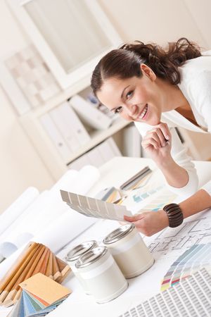 Young female interior designer at office with paint and color swatchの写真素材