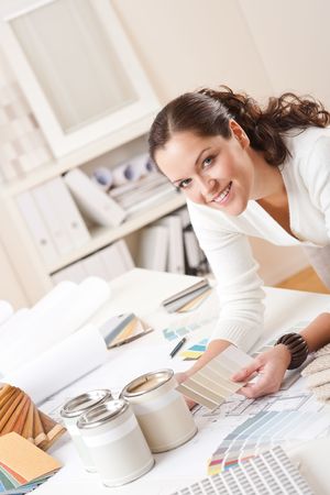 Young female interior designer at office with paint and color swatchの写真素材