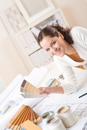 Young female interior designer at office with paint and color swatchの写真素材