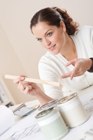 Female interior designer with cans of paint at officeの写真素材
