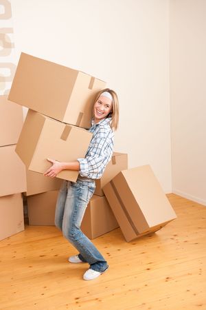 Moving house: Woman holding big carton box in new homeの写真素材