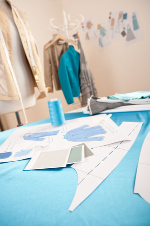 Fashion designer studio with professional equipment, sketches, mannequin, cloth