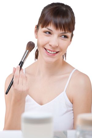 Body care: Young woman applying powder with make-up brush on white backgroundの写真素材