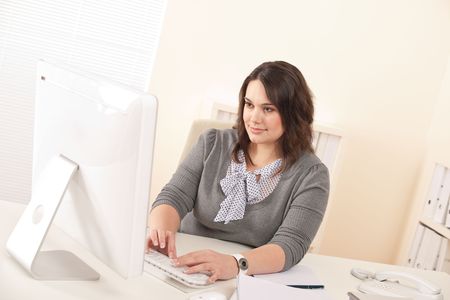 Young attractive business woman working at office with computerの写真素材
