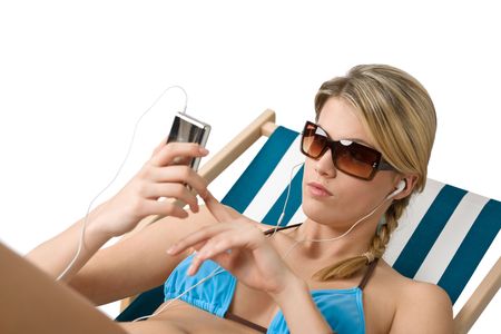 Beach - Happy woman in bikini relax on deck chair with musicの写真素材