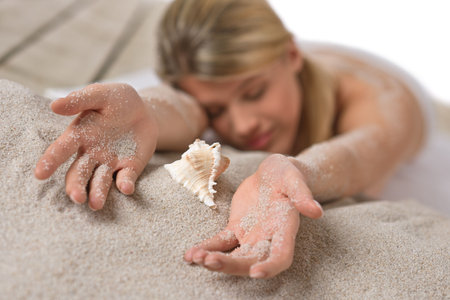 Beach - woman with starfish lying in sand sunbathingの写真素材