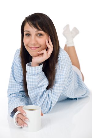 Happy young woman with coffee in pajamas on white backgroundの写真素材