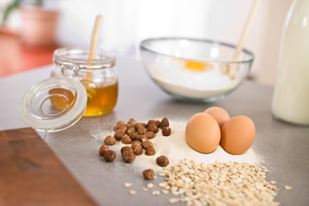Baking dough ingredients, honey, eggs, flour in kitchenの写真素材