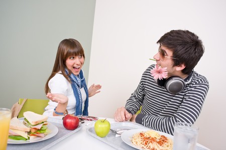 Student cafeteria - teenage couple having fun during lunch breakの写真素材