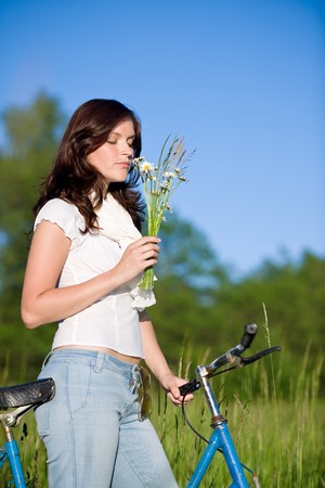 Woman with old-fashioned bike and bouquet of summer flower on sunny dayの写真素材