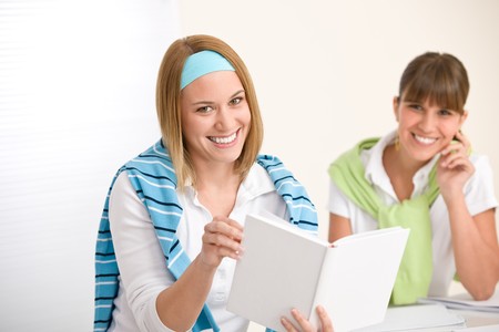 Student at home - two young woman study together with bookの写真素材