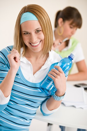 Student at home - smiling woman with bottle of water, study together with bookの写真素材