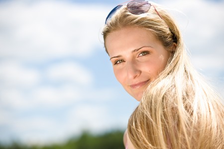 Portrait of blond woman with summer sky in natureの写真素材