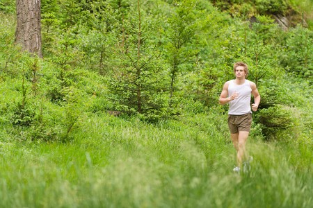 Morning run: Young man jogging in nature in sportive outfitの写真素材