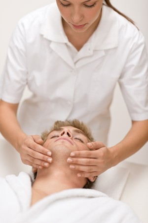 Male beauty - man receiving facial massage at luxury spaの写真素材
