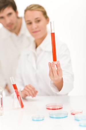 Scientists in laboratory - flu virus test tube with red liquidの写真素材