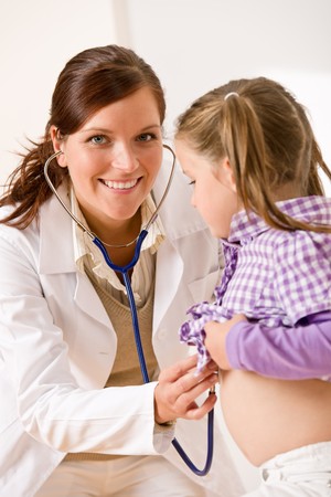 Female doctor examining child with stetoscope at medical officeの写真素材