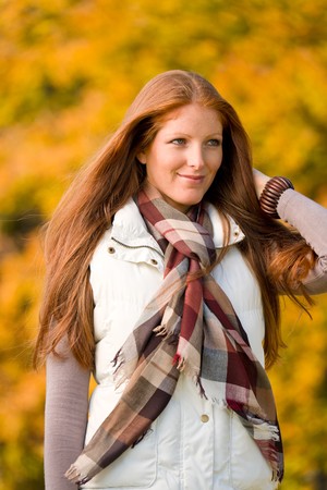 Autumn park - young attractive long red hair woman fashionの写真素材