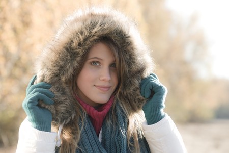 Winter fashion - woman with fur hood and gloves outside, desaturated colorsの写真素材