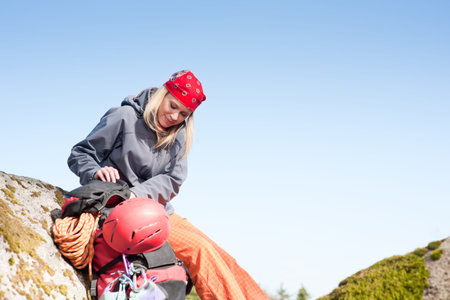 Active young woman rock climbing relax with backpack on mountainの写真素材