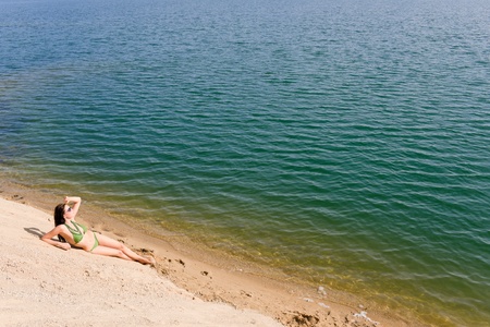 Summer beach young woman sunbathing in bikini aloneの写真素材