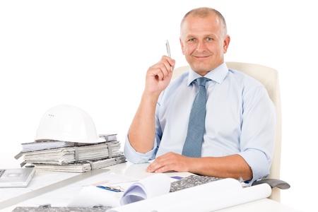 Portrait of professional architect with blueprints sitting behind tableの写真素材