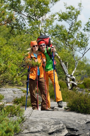 Young backpack couple with hiking poles beautiful panoramic view countrysideの写真素材