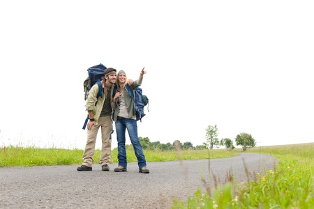 Hiking young couple backpack tramping on asphalt road countrysideの写真素材