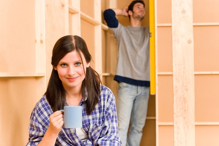 Home improvement smiling young couple fixing wall with water levelの写真素材