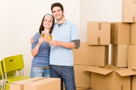 Moving into new home young happy couple celebrating toast Champagneの写真素材