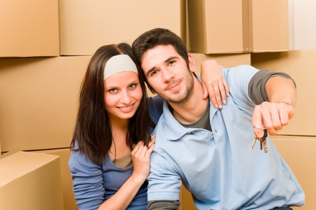 Moving into new home young happy couple holding house keysの写真素材