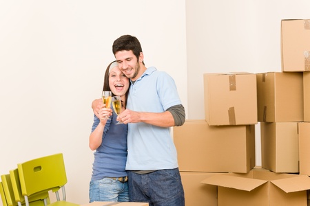 Moving into new home young happy couple celebrating toast Champagneの写真素材