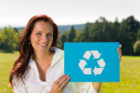 Recycling sign - Young attractive businesswoman hold symbol sunny meadowの写真素材