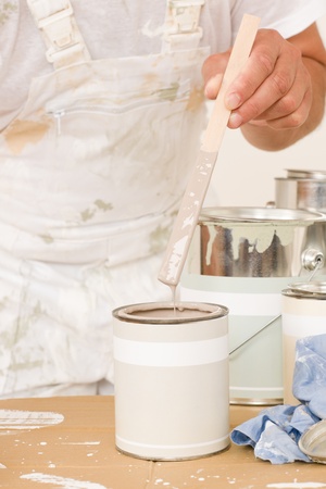 Home decorating close-up male mixing up paint color in canの写真素材