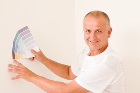 Home decorating mature male painter choose color swatches and canの写真素材