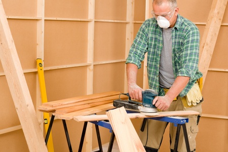 Handyman mature professional sanding wooden board diy new home renovationの写真素材