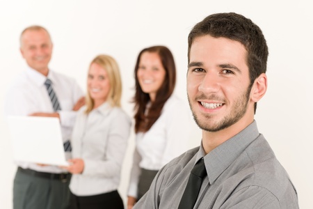 Business team handsome young man with colleagues posing in backの写真素材