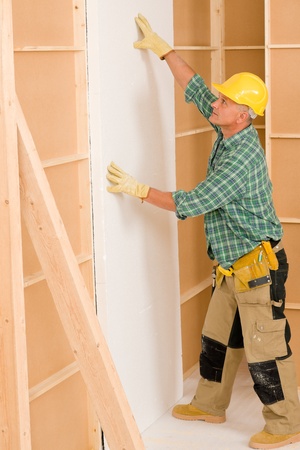 Mature handyman working on home renovations improvement isolating doorの写真素材