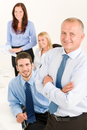 Business team senior businessman with attractive happy colleagues in officeの写真素材